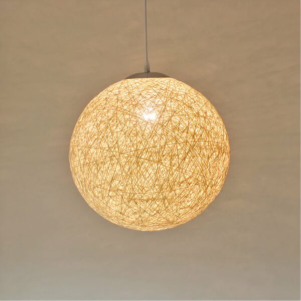 Rope ball chandelier with lighted bulb. A beige wall in the background.