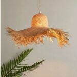 on a gray background, we see a suspension in the shape of a handmade straw hat made of raffia