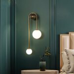 Modern living room wall light with 2 glass ball lights in a bedroom above a bedside table