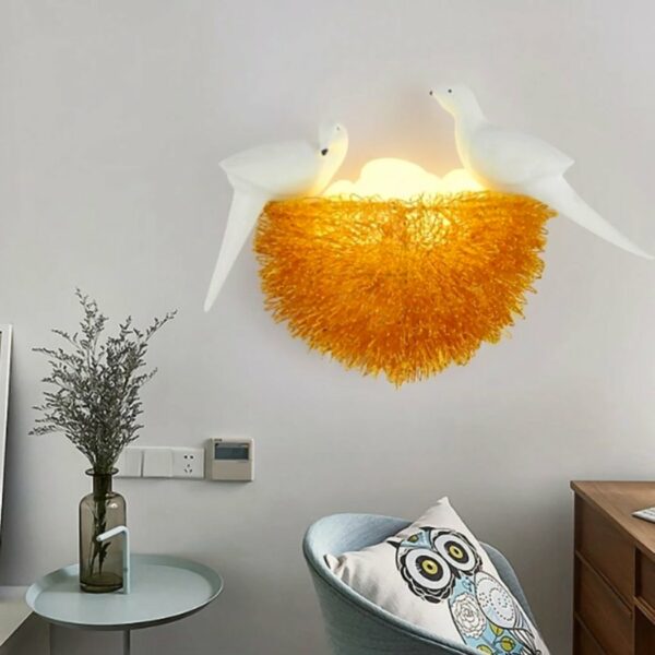 In the middle of the picture is a wall-mounted bird's nest. At the bottom left of the picture is a table with a transparent grey vase with branches in it. In the bottom-right corner is the top of an armchair with an owl-patterned cushion on top.