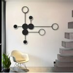 Black dot pattern wall light unlit near a staircase and white rocking chair
