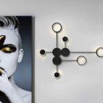 Black dot wall light glowing warm beside a black and white portrait photo