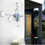 White dot pattern wall light unlit on an exterior wall beside a porch window