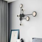 Black dot pattern wall light unlit above a bedside table with a book