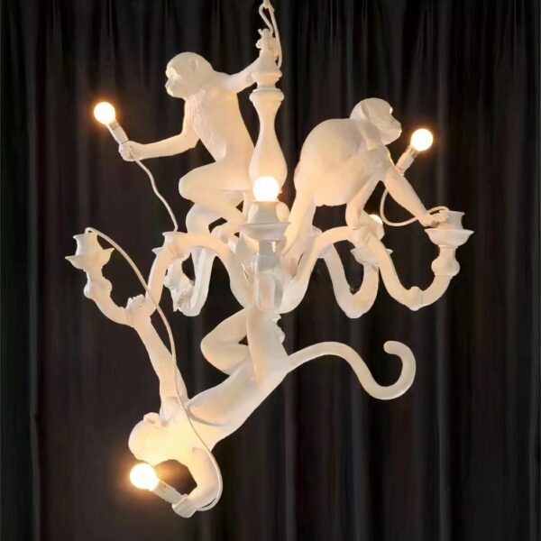 Hanging monkeys 3 animals hanging from the white chandelier, presented on a black background