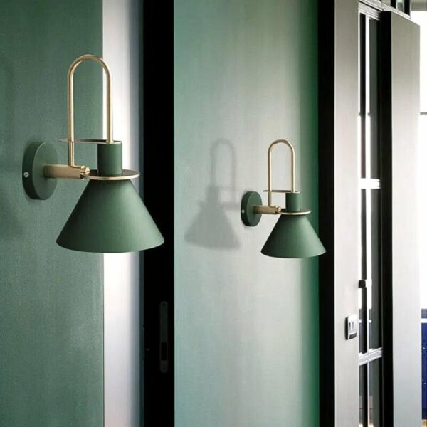 we see a green wall and two dark green Scandinavian-style wall sconces on top