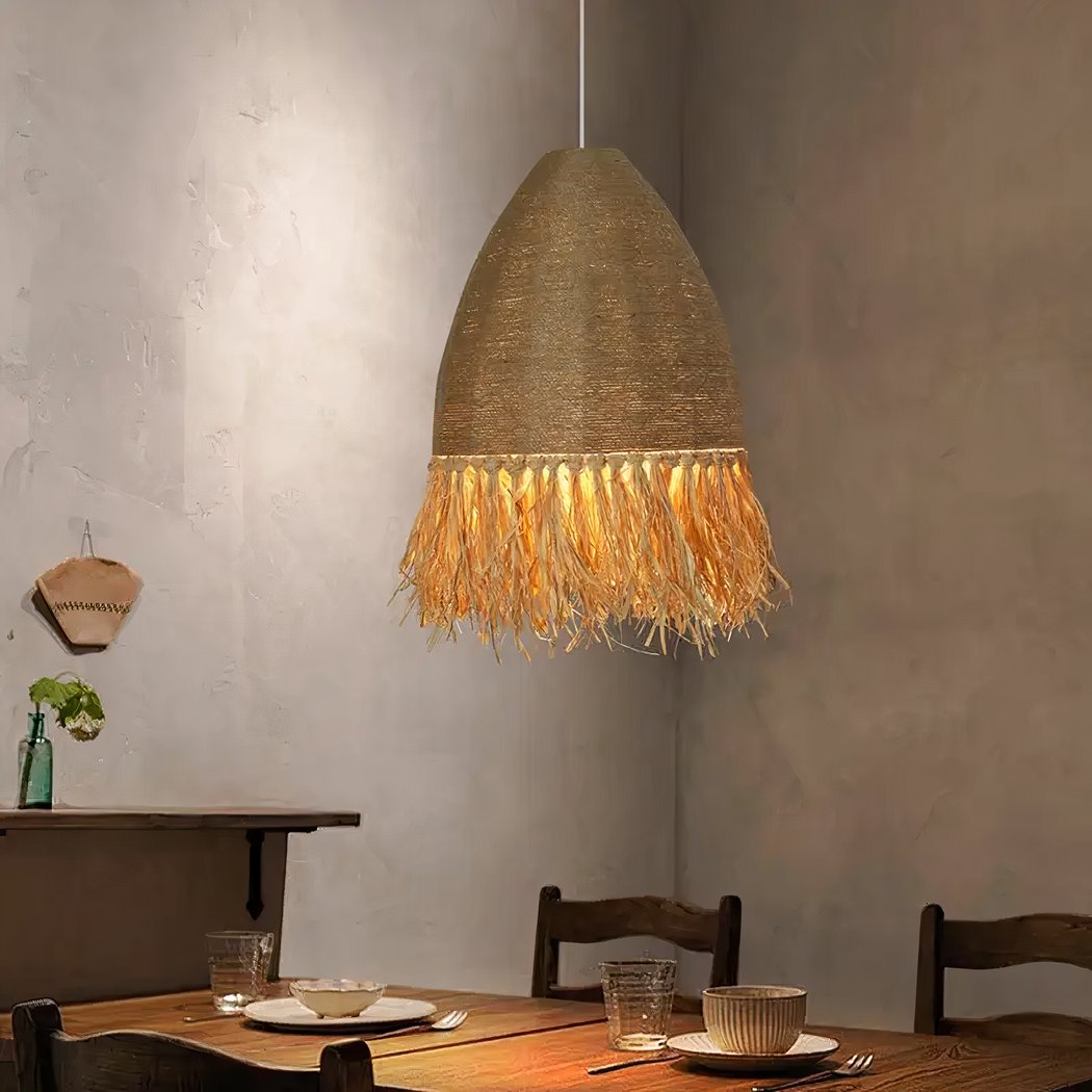Handmade straw and rope chandelier Handmade straw and rope chandelier suspended and lit above a dining room table set for dinner.