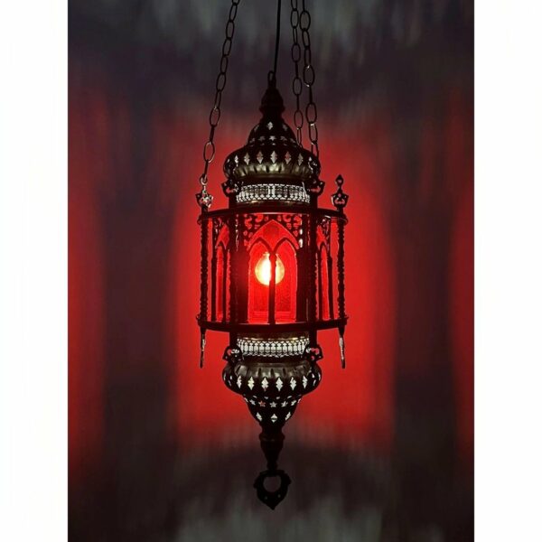 on voit sur un fond rouge une suspension en verre rouge dans le style marocain allumée