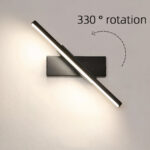 Slim adjustable bar wall light shown pivoted diagonally, glowing white