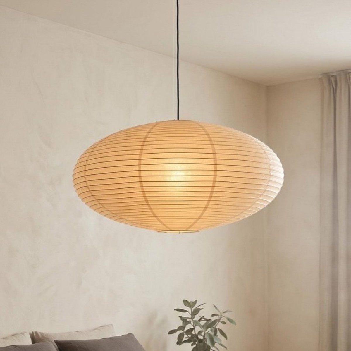 Oval rice paper pendant light glowing above a sofa