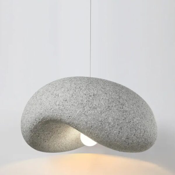 Organic pebble shaped pendant light with a granular grey texture and warm glow