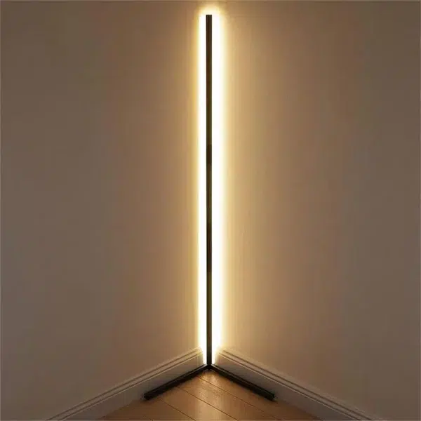Black corner LED floor strip glowing warm light along a wall corner