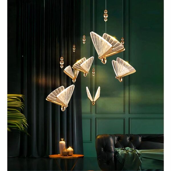 Cluster of gold and translucent butterfly shaped pendant lights above a dark living room