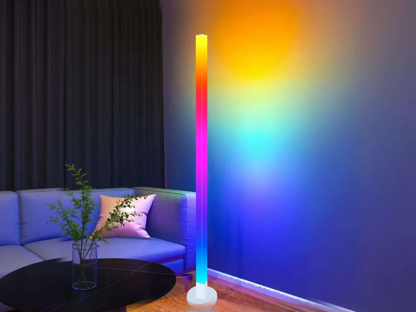 Rainbow LED corner floor lamp glowing beside a bed in a dim room