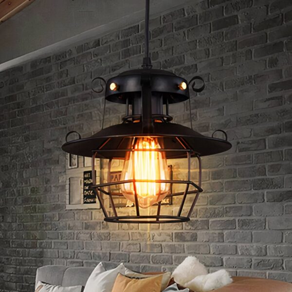 Black industrial pendant lantern with a wire cage against a brick wall