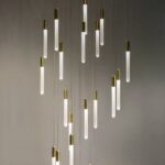Cluster of gold-tipped glass tube pendant lights at staggered heights