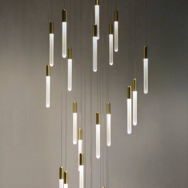 Cluster of gold-tipped glass tube pendant lights at staggered heights