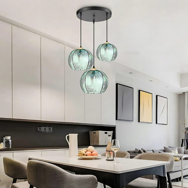 Three light pendant with ribbed teal glass globes above a dining table