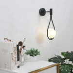 Close-up of the black loop wall light with a round white glass globe