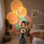 Halo sunset floor lamp glowing colorfully behind a woman filming with a ring light