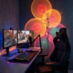 Halo sunset floor lamp casting colorful light circles on the wall by a gaming desk