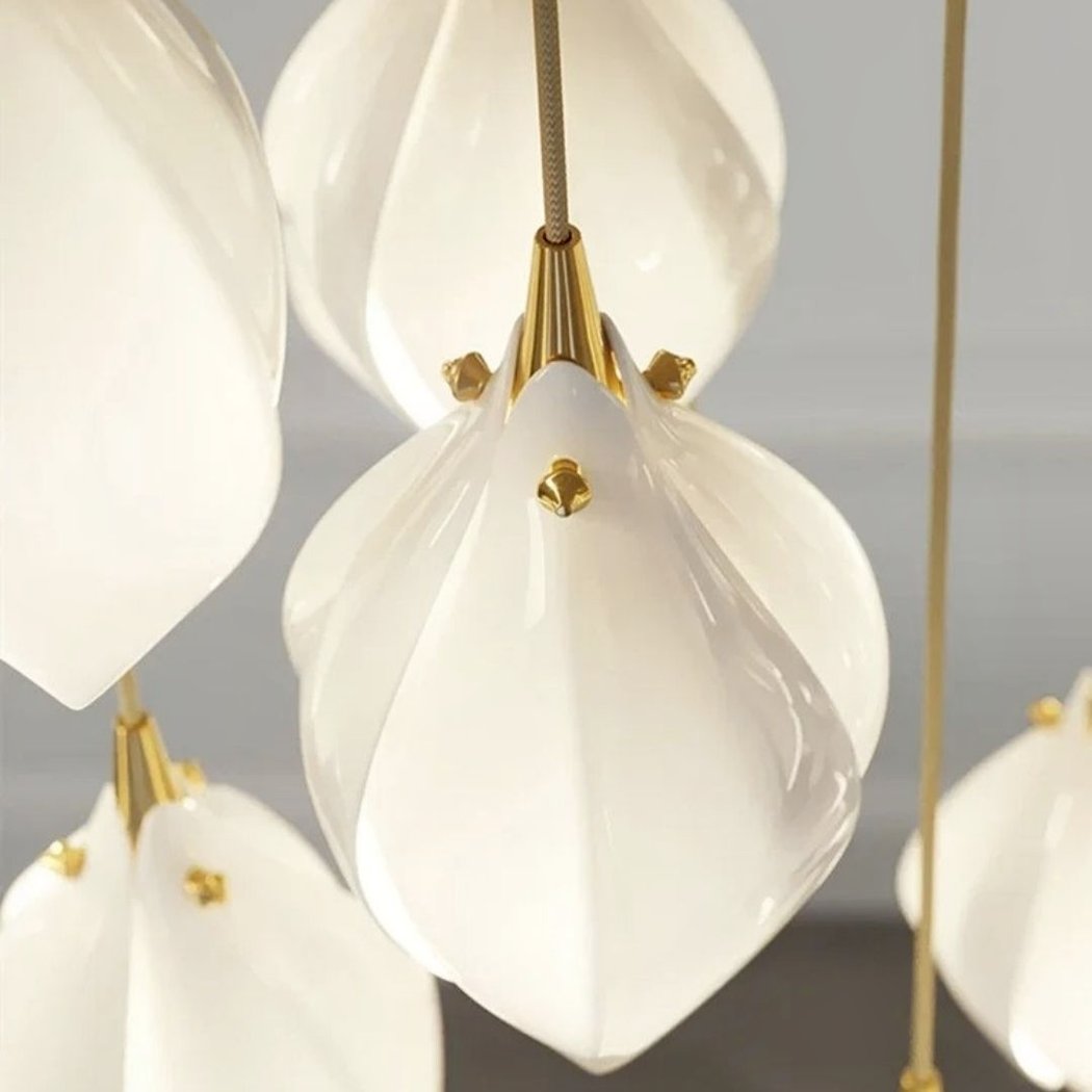Close-up of layered white ceramic magnolia petals with gold accents on the flower pendant
