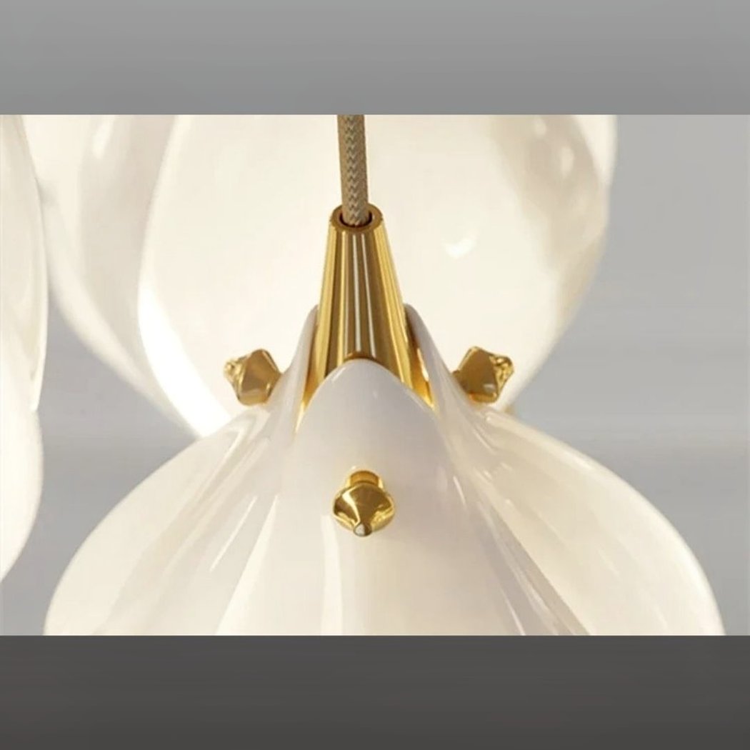 Close-up of the gold clasps joining curved white petals at the top of the pendant