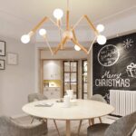 Black and wood spider chandelier hanging above a round table in a Christmas decorated room