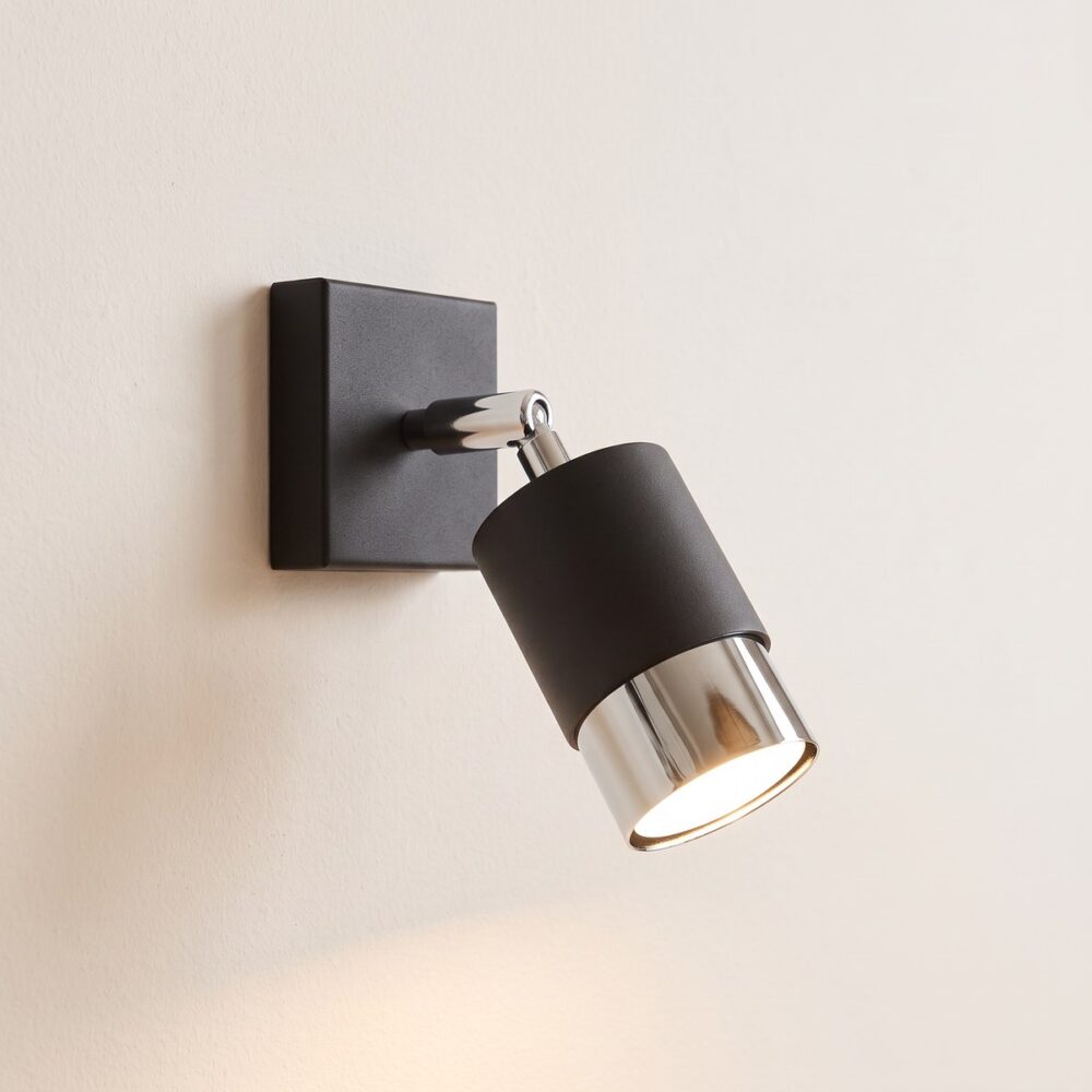Adjustable spot wall light in black steel with chrome or gold band