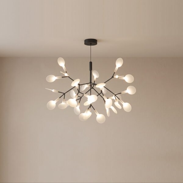 Original modern gold tree-shaped LED pendant chandelier suspended and lit above a dining table.